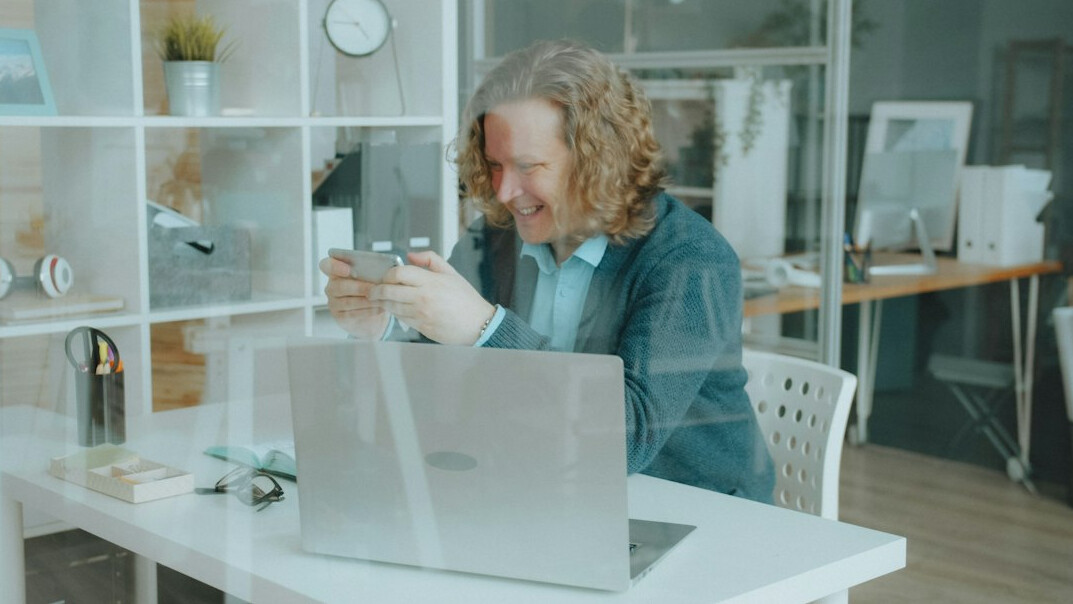 Small team of Croatian IT professionals discussing software on a laptop in an office